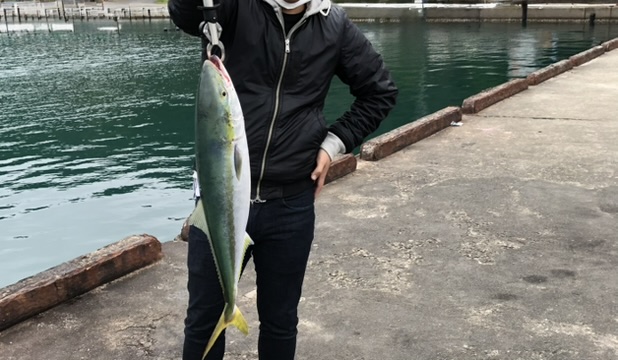 フィッシュグリップでブリを持っている釣り人